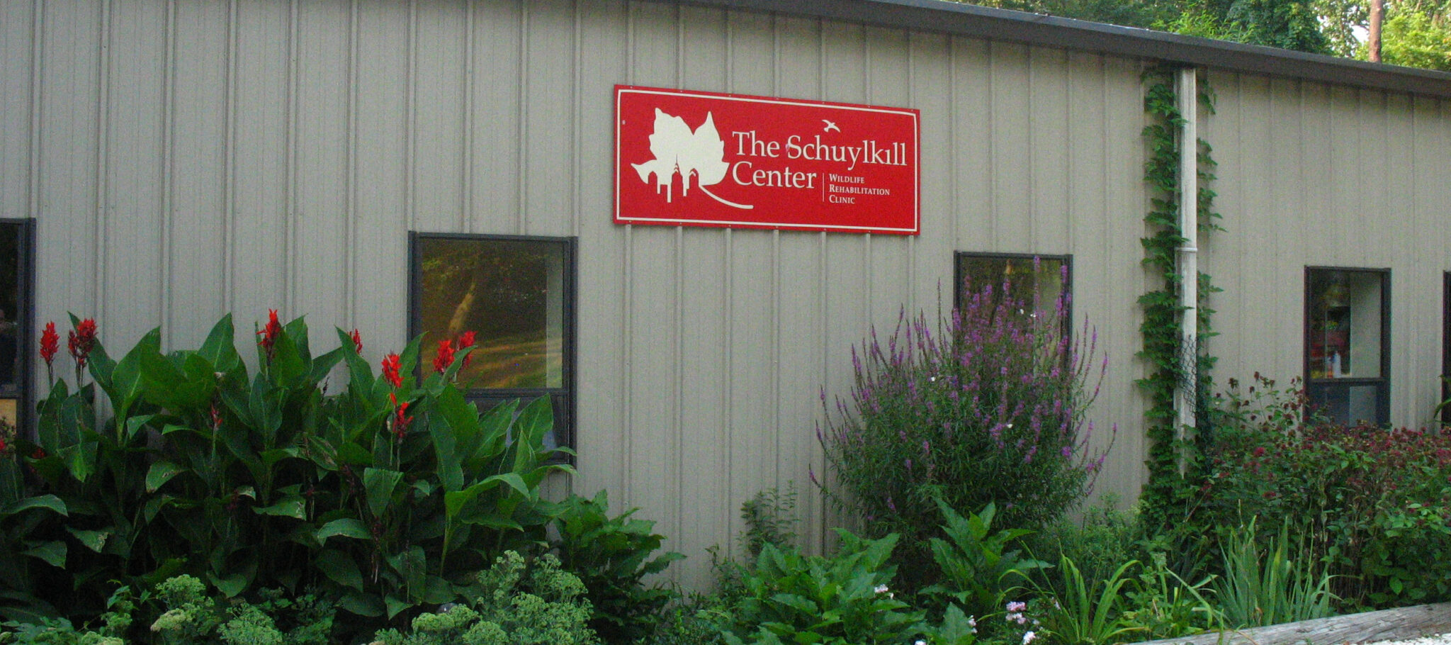 The front of the Wildlife Clinic Building with a red sign that reads "The Schuylkill Center Wildlife Rehabilitation Clinic."