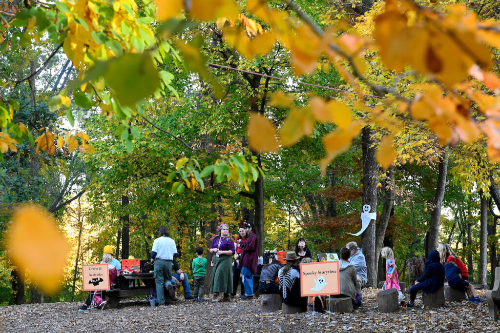 A crowd of families gather in an fall forest during Halloween Hikes and Hayrides at the Schuylkill Center.