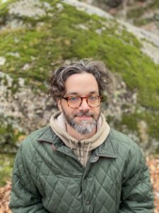 Portrait of Narendra Haynes in a winter jacket sitting outdoors. 